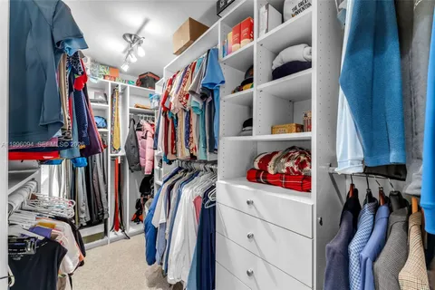 a view of walk in closet with clothes