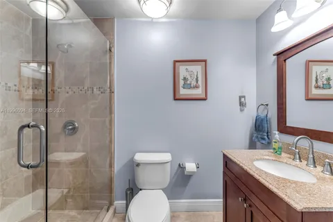 a bathroom with a granite countertop sink toilet and shower