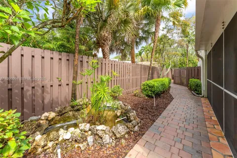 a view of a backyard with potted plants and wooden fence
