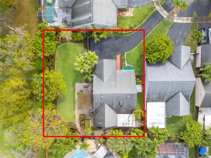 an aerial view of a house with a yard and swimming pool