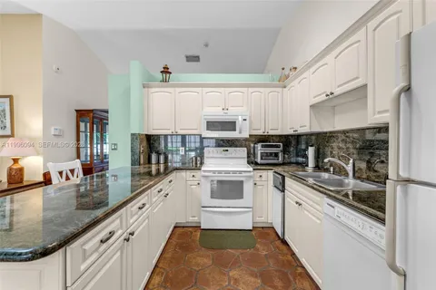 a large kitchen with stainless steel appliances granite countertop a sink and cabinets