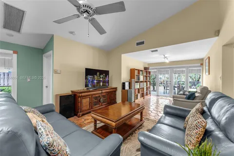 a living room with furniture a flat screen tv and a large window
