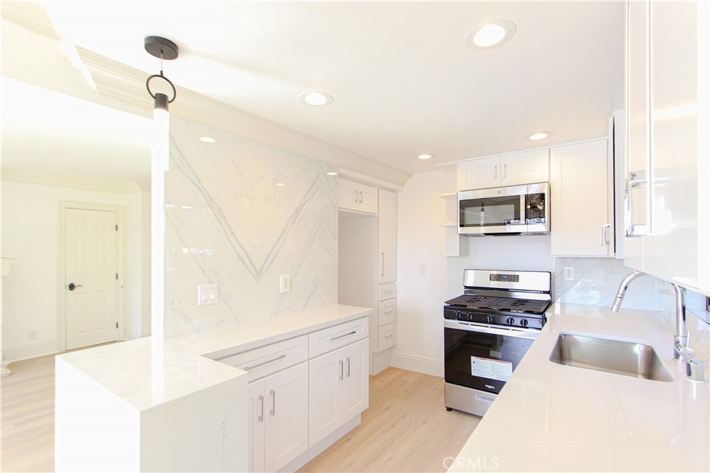 a kitchen with stainless steel appliances white cabinets and a refrigerator