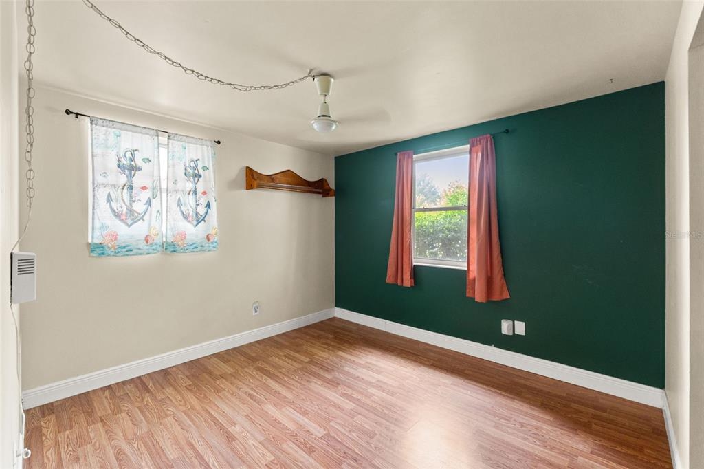 9658 Bayside Court Spring Hill, FL 34608 - Photo 29 of 34 a view of empty room with window and wooden floor