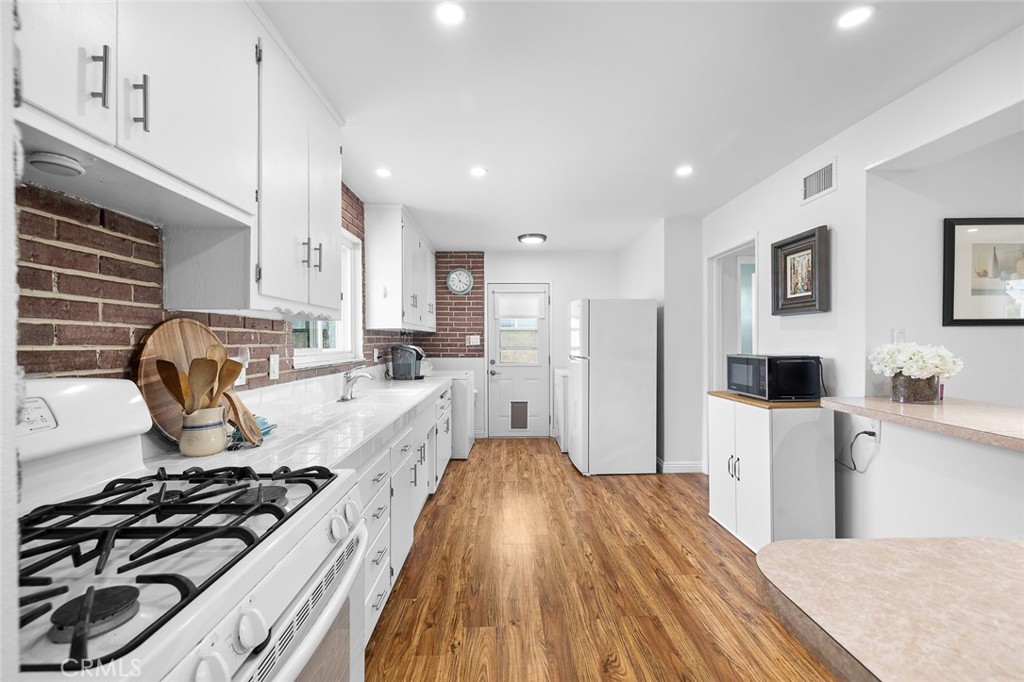 5472 Marion Avenue Cypress, CA 90630 - Photo 11 of 36 a kitchen with stainless steel appliances a stove a sink a refrigerator and cabinets