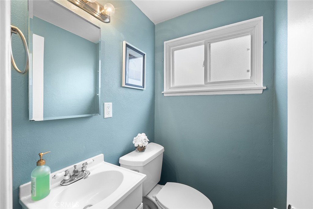 5472 Marion Avenue Cypress, CA 90630 - Photo 15 of 36 a white toilet sitting next to a bathroom sink