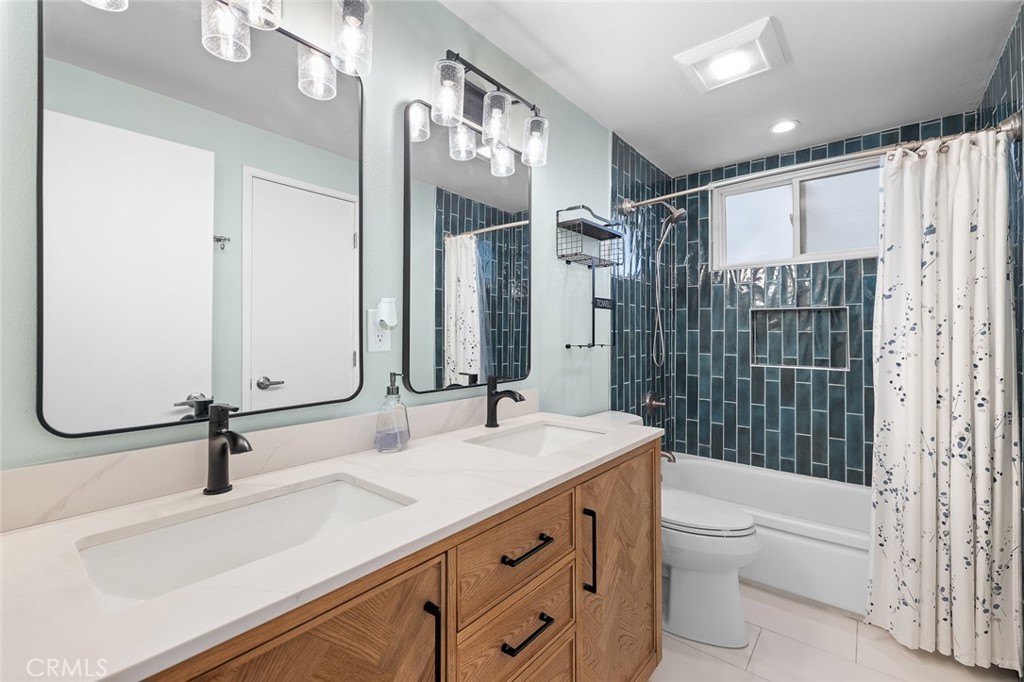 5472 Marion Avenue Cypress, CA 90630 - Photo 16 of 36 a bathroom with a double vanity sink toilet mirror and shower