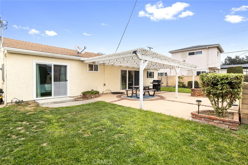 5472 Marion Avenue Cypress, CA 90630 - Photo 28 of 36 a view of a swimming pool with table and chairs under an umbrella