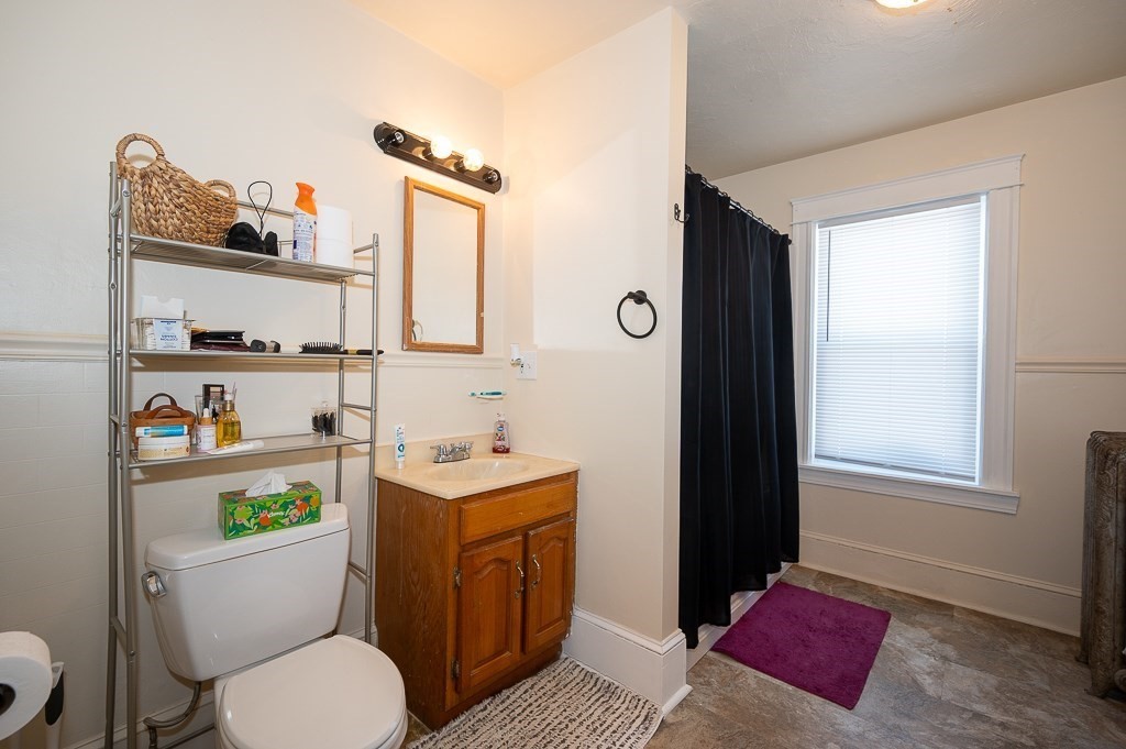 104 1/2 Rodney Street Worcester, MA 01605 - Photo 6 of 25 a bathroom with a toilet a sink and a mirror