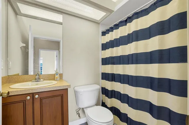 a bathroom with a sink a toilet a shower curtain