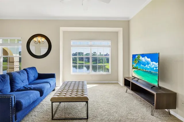 a living room with furniture a flat screen tv and a window