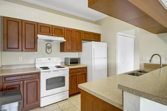 a kitchen with a stove top oven and refrigerator