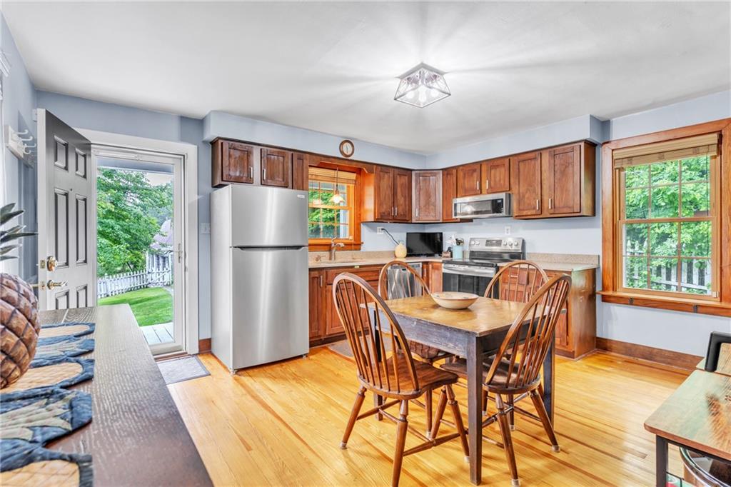 461 Manor Road Wexford, PA 15090 - Photo 6 of 43 a kitchen with stainless steel appliances granite countertop a refrigerator a sink a stove a dining table and chairs with wooden floor