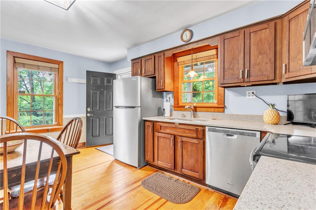 461 Manor Road Wexford, PA 15090 - Photo 7 of 43 a kitchen with stainless steel appliances granite countertop a refrigerator a sink dishwasher a stove a dining table and chairs with wooden floor