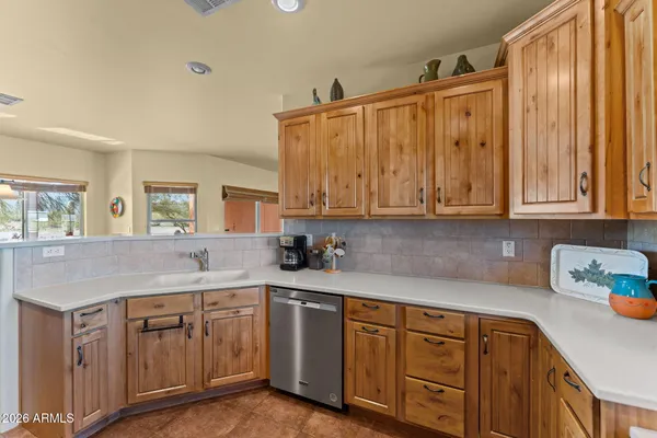 a kitchen with stainless steel appliances granite countertop a sink a stove cabinets and wooden floor
