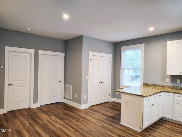 a kitchen with granite countertop cabinets and wooden floor