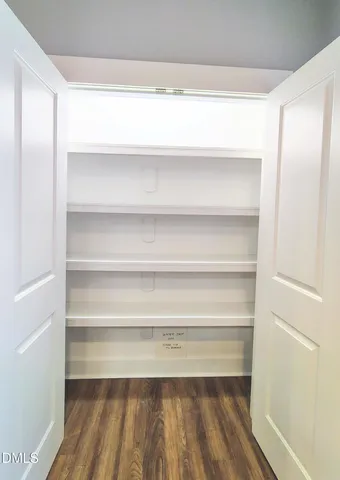 a view of walk in closet with empty racks