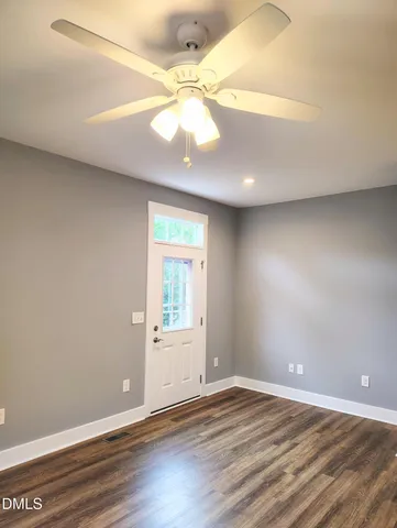 an empty room with a window and wooden floor