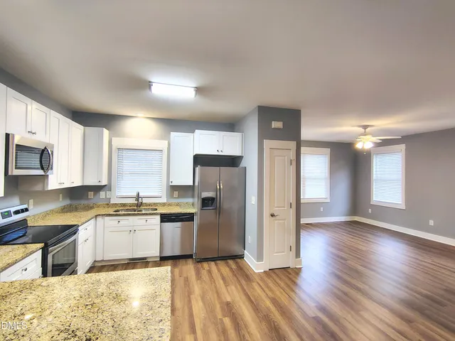 a kitchen with granite countertop stainless steel appliances and wooden cabinets