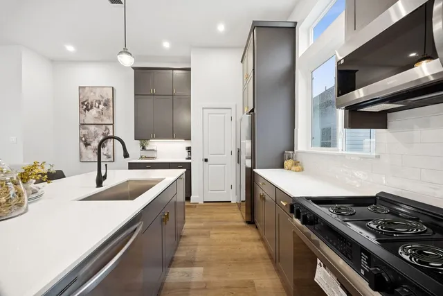 a kitchen with stainless steel appliances granite countertop a sink stove and refrigerator