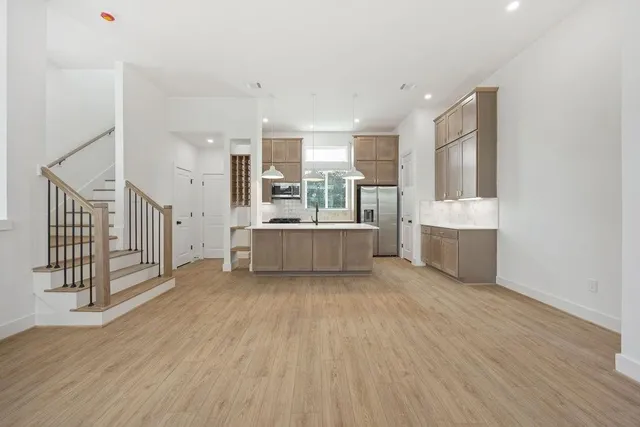a view of a big room with wooden floor and windows
