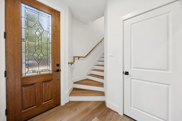a view of a hallway with wooden floor and entryway