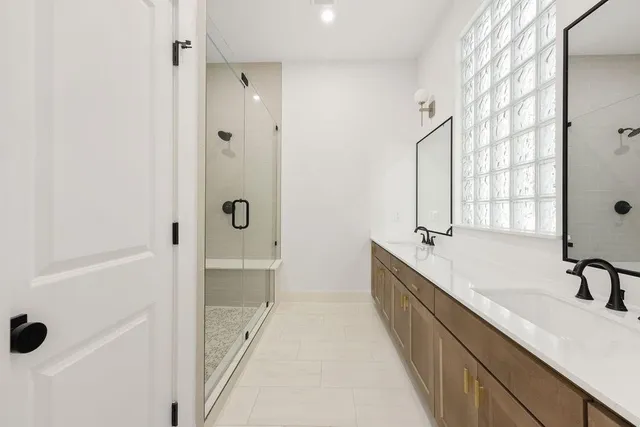 a bathroom with a double vanity sink a mirror and a bathtub