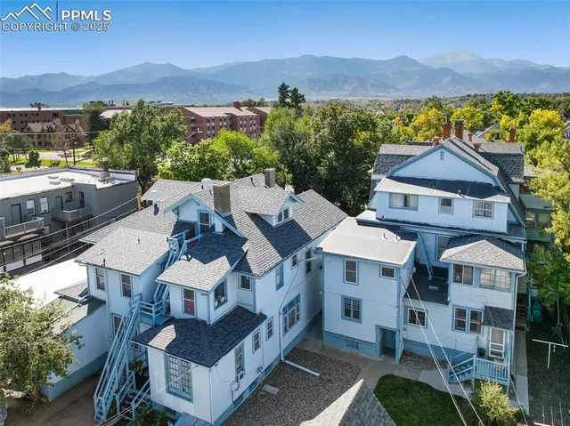an aerial view of multiple houses with a city street