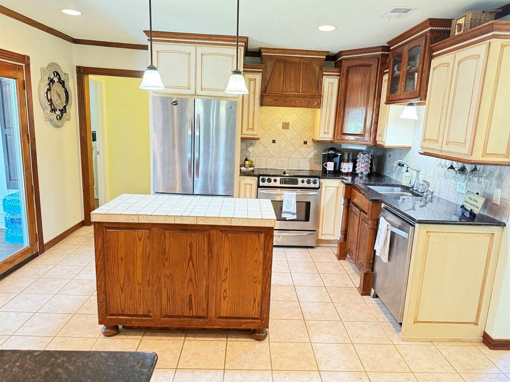3420 Springfield Road Springtown, TX 76082 - Photo 22 of 38 a kitchen with stainless steel appliances granite countertop a stove a sink dishwasher and a refrigerator
