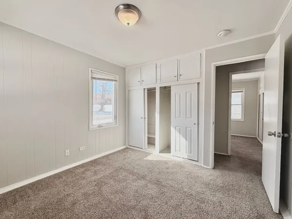 a bedroom with a bed and a table chair