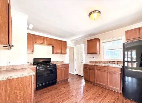 a kitchen with stainless steel appliances granite countertop a stove a sink dishwasher and a microwave oven with wooden floor
