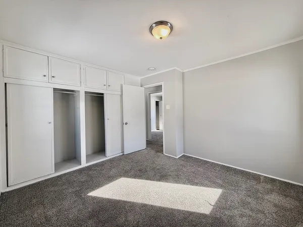 an empty room with windows and closet