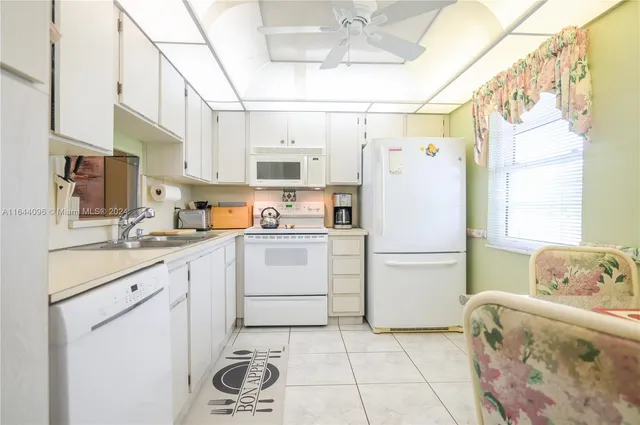 a kitchen with a sink a refrigerator and cabinets
