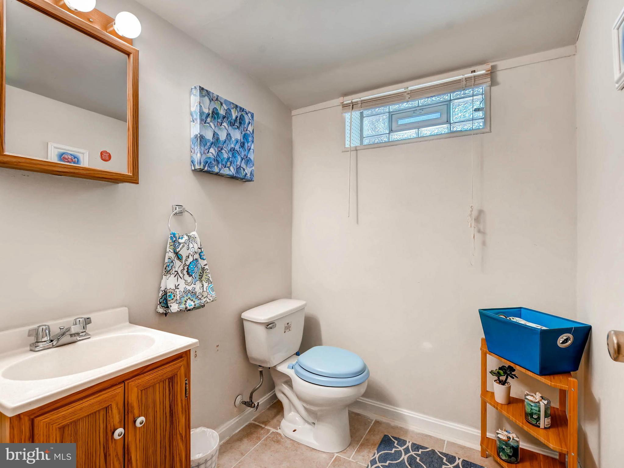 4781 Byron Road Baltimore, MD 21244 - Photo 22 of 28 a bathroom with a toilet a sink and wooden floor