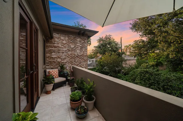 a view of a balcony with chair and potted plants