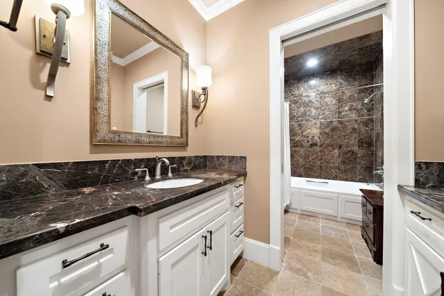 a bathroom with a sink and a mirror with bathtub