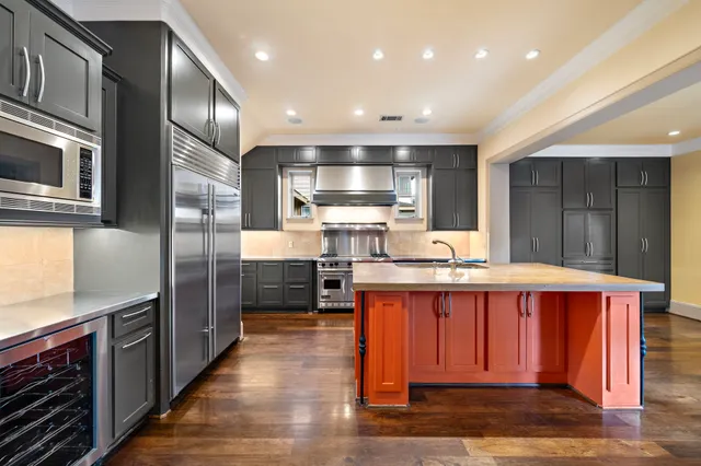 a kitchen with stainless steel appliances granite countertop a stove refrigerator and cabinets