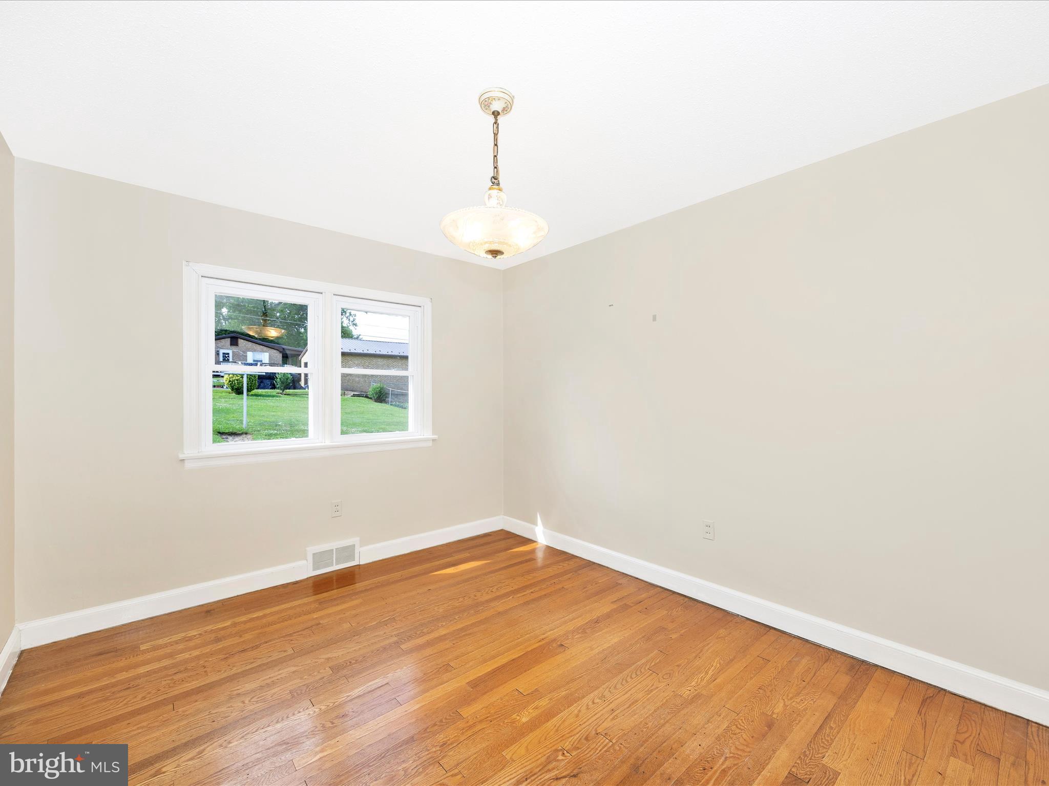6 Park View Boonsboro, MD 21713 - Photo 10 of 64 an empty room with wooden floor a exposed radiator and a window