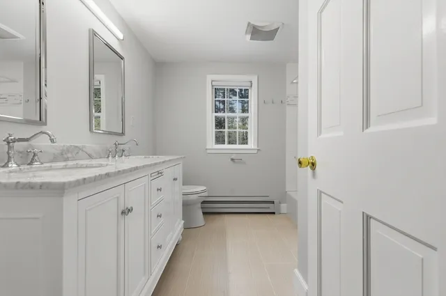 a bathroom with a sink a toilet and a window