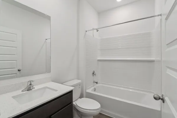a bathroom with a bathtub shower sink vanity and toilet