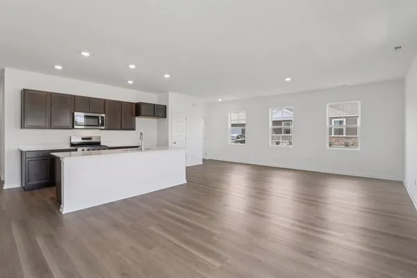 a view of kitchen with microwave a refrigerator and cabinets