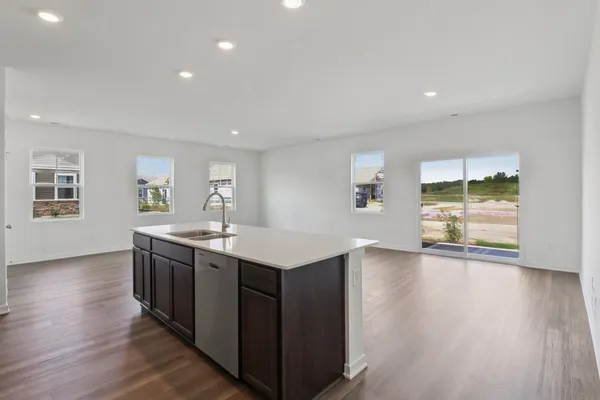 a kitchen with a sink and wooden floor