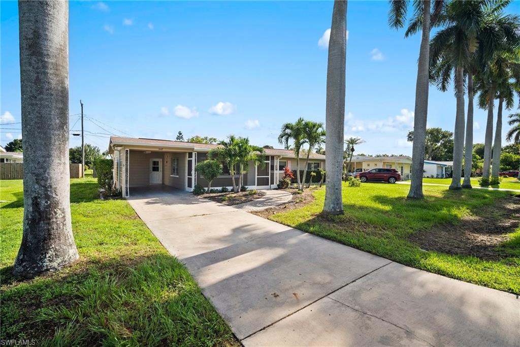 1449 Charles Road Fort Myers, FL 33919 - Photo 1 of 40 Single story home featuring a carport and a front yard