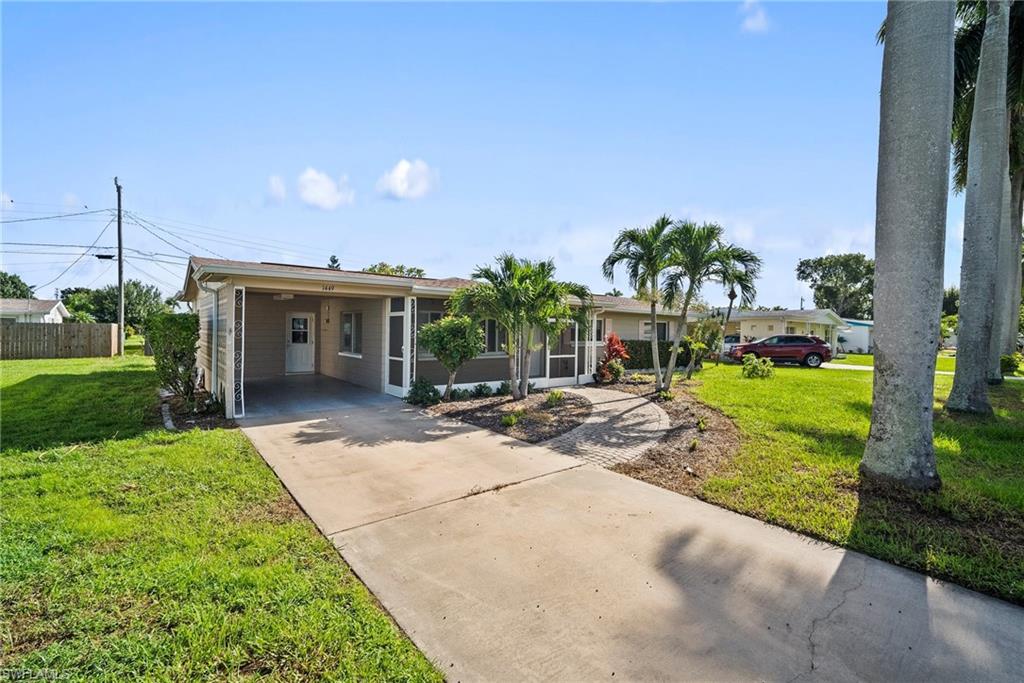 1449 Charles Road Fort Myers, FL 33919 - Photo 2 of 40 Ranch-style house featuring a carport and a front yard