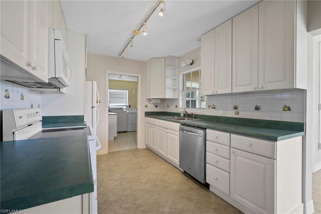 1449 Charles Road Fort Myers, FL 33919 - Photo 28 of 40 Kitchen with light tile patterned flooring, decorative backsplash, white appliances, sink, and washer and dryer