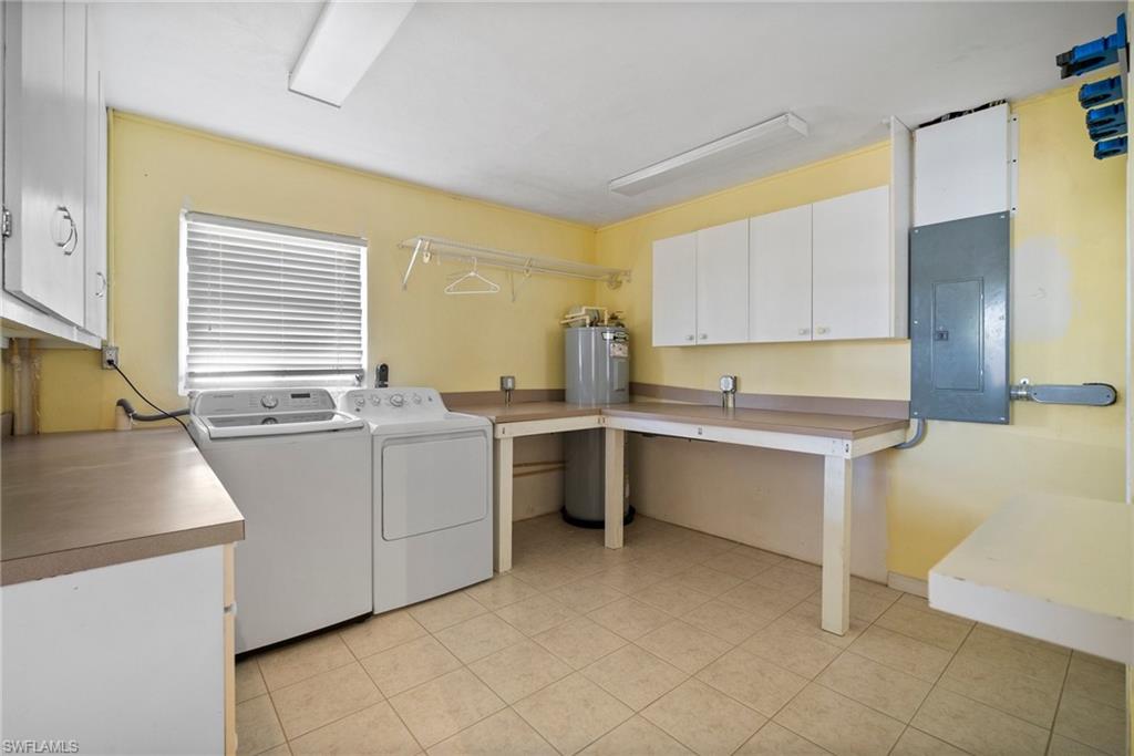 1449 Charles Road Fort Myers, FL 33919 - Photo 29 of 40 Washroom featuring washing machine and clothes dryer, cabinets, light tile patterned floors, and electric panel