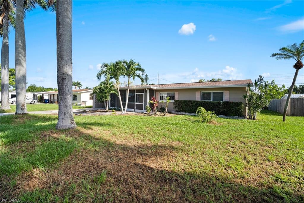 1449 Charles Road Fort Myers, FL 33919 - Photo 4 of 40 Back of house featuring a lawn
