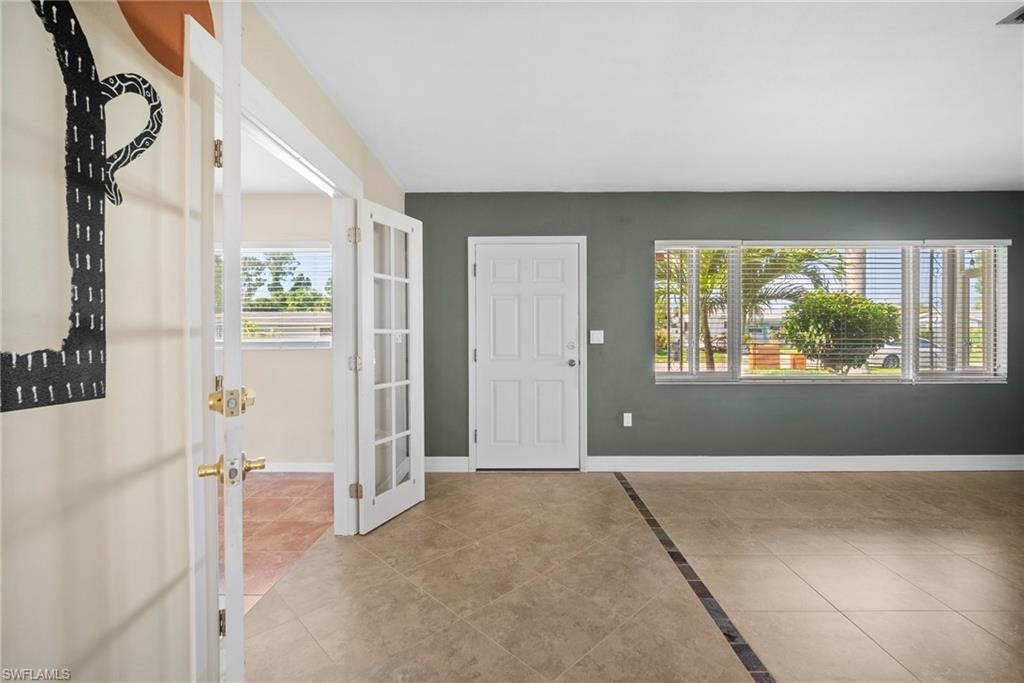 1449 Charles Road Fort Myers, FL 33919 - Photo 6 of 40 Foyer entrance with a wealth of natural light and light tile patterned floors