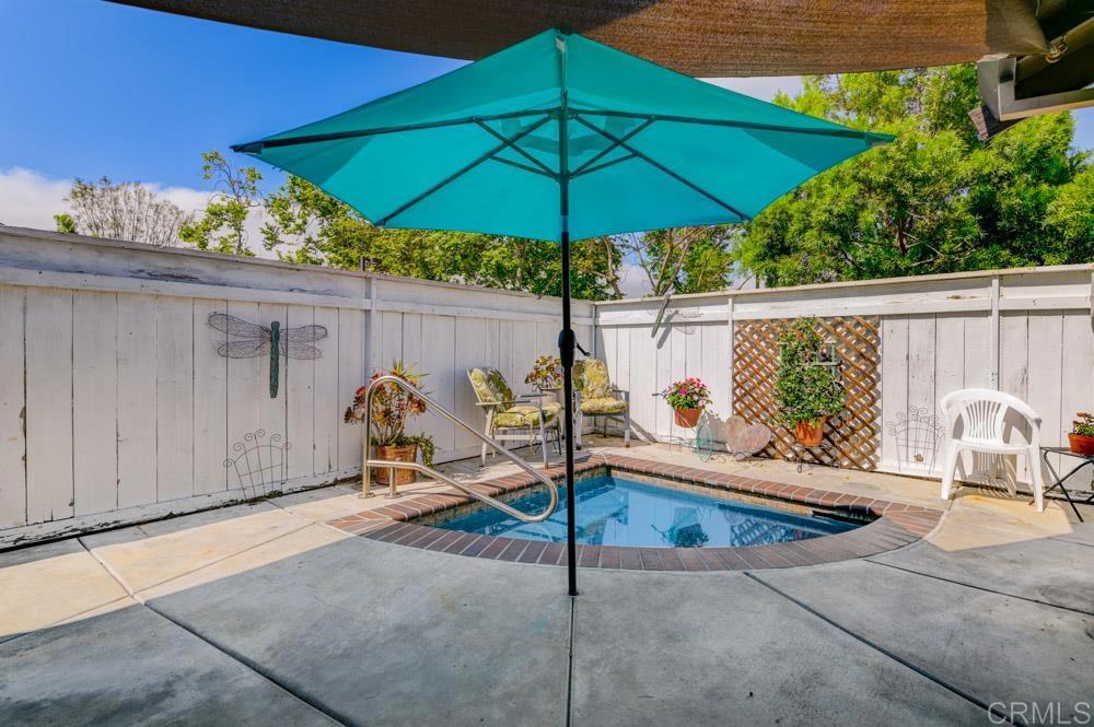 a view of a balcony with chairs and umbrella