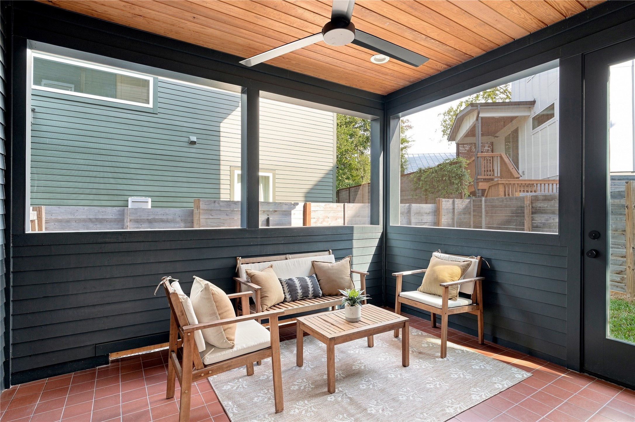 5506 Hudson Street, Unit 2 Austin, TX 78721 - Photo 6 of 24 Natural wood plank ceilings and dark wood siding frame this inviting temperature controlled screened porch space.